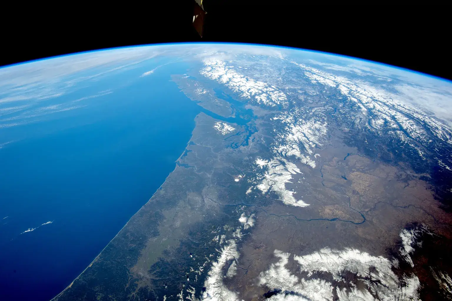 The snow-covered Cascade Range in the foreground gives way to the Rocky Mountains and Coast Mountains in Canada, with Vancouver Island offshore, in a photograph taken Feb. 28, 2015, by an astronaut looking north from the International Space Station. (NASA/NASA)