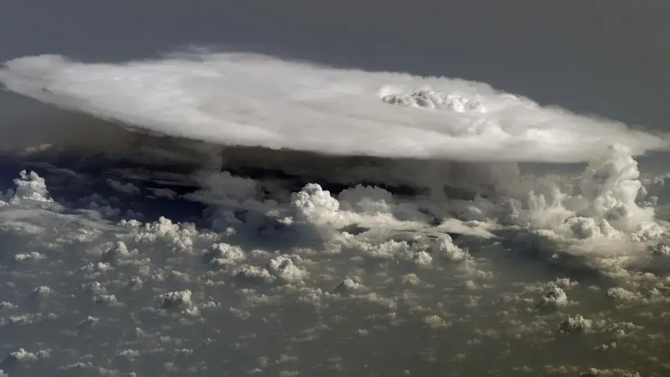 Looming high above a layer of fluffy, popcorn-like clouds over Africa is a large cumulonimbus cloud, which looks like an enormous shelf of water vapor. This image was captured by an Expedition 16 crewmember of the International Space Station. Due to its shape, this type of cloud formation is often referred to as an "anvil cloud." Source: NASA https://www.space.com/earth-day-amazing-nasa-photos.html