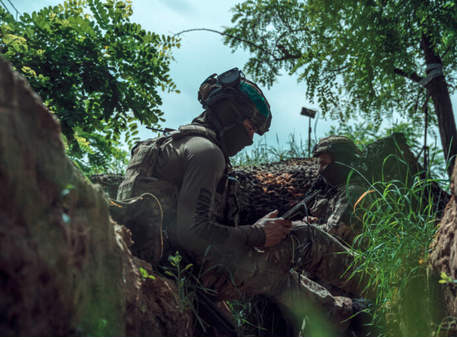 Ukrainian soldiers directing a drone, its antenna visible against the sky. Source: https://war.ukraine.ua/imagebank-category/defenders-of-freedom/