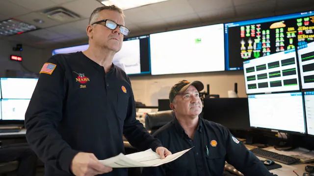 When Mars (an oil production system) was first installed, it stood largely alone in the Gulf of Mexico. Today, it anchors a growing offshore community of production platforms that include Ursa, Olympus, and Vito, forming a connected system helped shape by shared experiences and technical progress. Photograph: two men in a platform control room with multiple computer monitors displaying data and charts. Source: https://www.shell.us/about-us/what-we-do/forward/mars.html